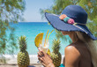 Young woman drinking cocktails on the beach. Pineapples in the background. Summer and party concept.