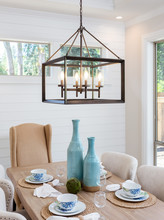 Dining Room Table And Pendant Light Fixture In New Luxury Home. Table Is Set With Napkins, Bowls, Plates, And Wine Glasses