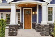 New Luxury Home Exterior Detail: New House Front Door And Covered Patio With Arch, Columns, And Elegant Design