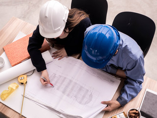 Wall Mural - Top view teamwork concept, Engineer and workers discussing project of new building. ,Team of architects Asian people in group on construction site check documents and business workflow.