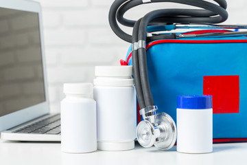 Wall Mural - Stethoscope, laptop and pills on the white table