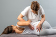 Female therapist doing osteopathic spine treatment on patient.