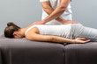 © karelnoppe - Male osteopath doing back massage on young woman.