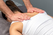 © karelnoppe - Therapist hands applying pressure on female shoulder blades.