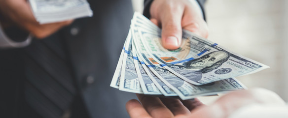 Businessman giving or paying money, US dollar bills