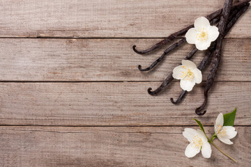 Vanilla sticks with flower and leaf on a old wooden background with copy space for your text. Top view