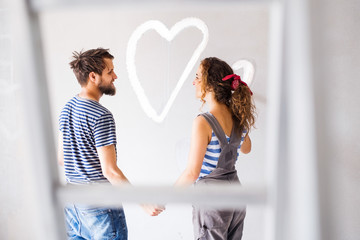 Wall Mural - Couple painting heart on the wall in their house.