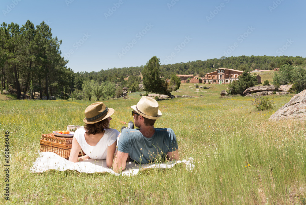 Joven pareja haciendo un picnic en un soleado día de verano en el campo ...