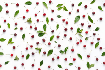 Wall Mural - Cherries and green leaves isolated on white background. Pattern of cherry with green leaves. Abstract food background. Top view.	