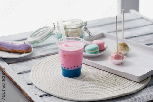 Plakat herbata bąbelkowa w kolorze różowym i niebieskim w plastikowym kubku ze słomką. Miękkie, piękne kolory