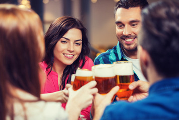 Wall Mural - friends drinking beer and clinking glasses at pub