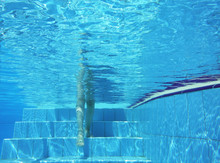 Underwater Shot Of Legs Stepping On Pool Stairs