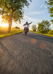 Wall Mural - Dark motorbiker riding high power motorbike in sunset