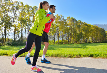 Young couple jogging in park at morning. Health and fitness.