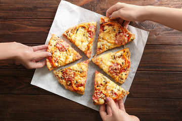 Poster - Hands taking pizza slices from napkin, close up view