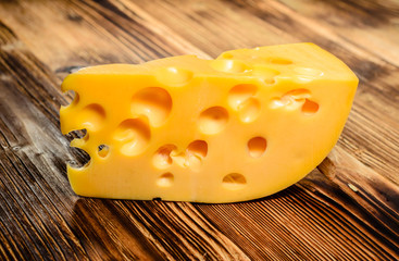 Piece of cheese on wooden table