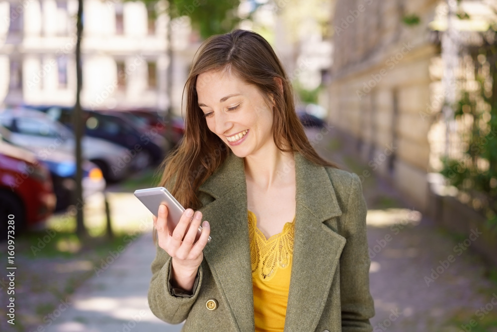 Young woman reading a text message with a smile Stock Photo | Adobe Stock