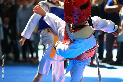 Fototapety Taekwondo  dzieciaki-walczace-na-scenie-podczas-zawodow-taekwondo