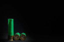 Used Casings From Shotgun Ammunition Are Located In The Left Side Of The Frame, Black Background