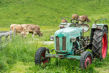 Old Tractor On Meadow. Beautiful Mountain View In The Alps