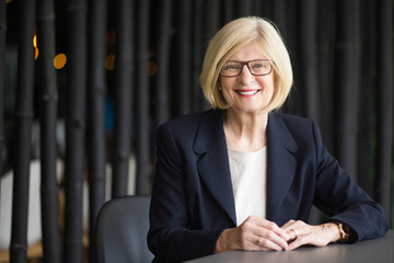 Portrait of Happy Senior Business Woman at Table