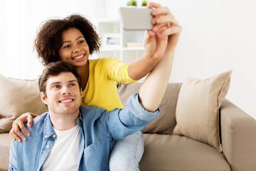 Poster - happy couple with smartphone taking selfie at home