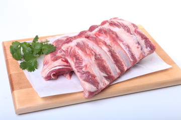 Raw pork ribs with herbs and spices on wooden board. Ready for cooking.