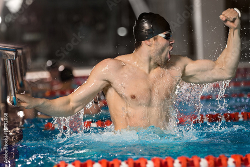 Fotomural Happy male swimmer holding starting block