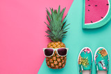 Fashion Hipster Pineapple Fruit. Bright Summer Color, Accessories. Tropical pineapple with Sunglasses, Stylish Handbag Creative Art concept. Minimal style. Pink blue summer party background