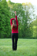 © Елена Кравчук - Woman stretching standing back exercise in green park, morning, sport, healthy lifestyle