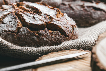 Wall Mural - Delicious fresh bread inside a sack on wooden background