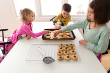 Three Children Decorating Freshly Baked Cookies, Elevated View