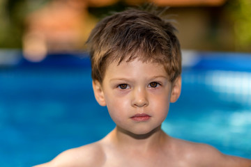 young boy playing in swimming pool wirh float ring