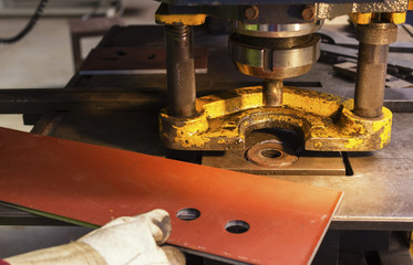 Electrical powerful machine for punching. You can see two holes already pierced.