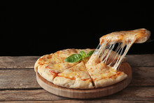Tasty Sliced Pizza With Basil Leaves On Wooden Table