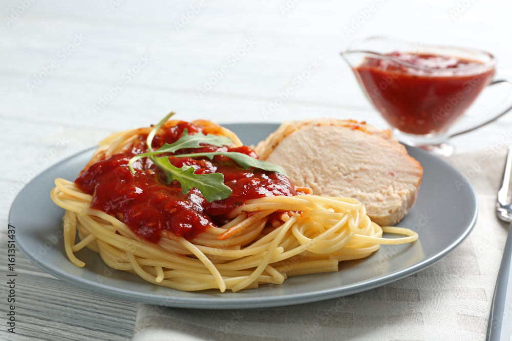 Delicious pasta with chicken parmesan slices and sauce on plate