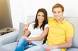 © Atstock Productions - Young mixed race couple sitting on the couch in living room