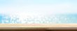 Leinwandbild Motiv Wood table top on blue summer sparking sea water bokeh banner background