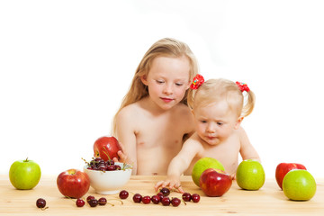 two little girls eat fruit