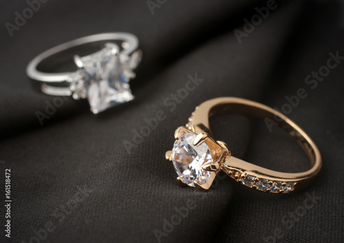 Zdjęcie XXL dwa pierścienie biżuterii z diamentami na czarnym płótnie, nieostrość