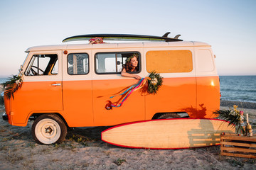 bus with a surfboard on the roof is a parked near the beach