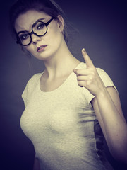 Woman wearing eyeglasses pointing at camera