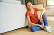 © goodluz - Woman sitting on wooden floor, relaxed
