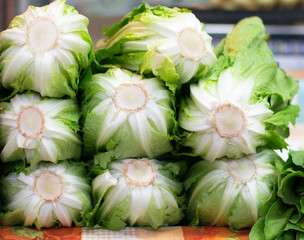 Fresh romain lettuces in a market stand.