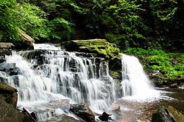 beautiful flowing waterfall over rocks in the forest