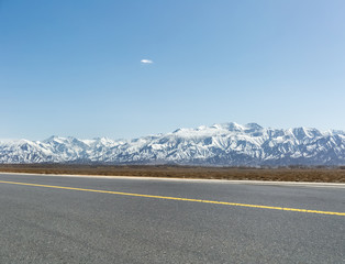 Poster - snow mountain with empty asphalt road