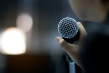 Blurred Of Businessman Or Speaker Hand Holding Microphone For Speech Presentation In Conference Hall Or Meeting Hall In University