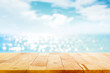 Leinwandbild Motiv Wood table top on blur sparkling sea water and summer sky background