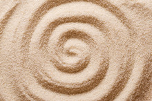 Spiral In The Sand. Archimedean Spiral Made With The Finger In Dry Ocherous Sand. Macro Photo Close Up From Above.