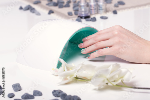 Photographie Closeup finger nail care by manicure specialist in beauty salon